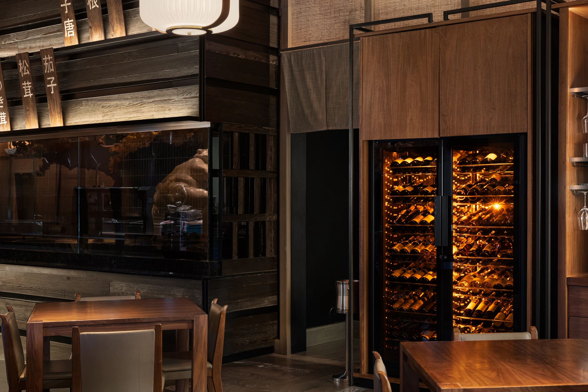 ShowCave installation in a restaurant, with a wall of illuminated glass cellars, to enhance the wine list and the customer experience. Secondary view of the installation.